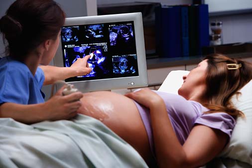 Pregnant woman receiving ultra sound with female doctor